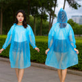 Front and back views of a woman wearing a translucent blue plastic poncho with a hood, standing outdoors.