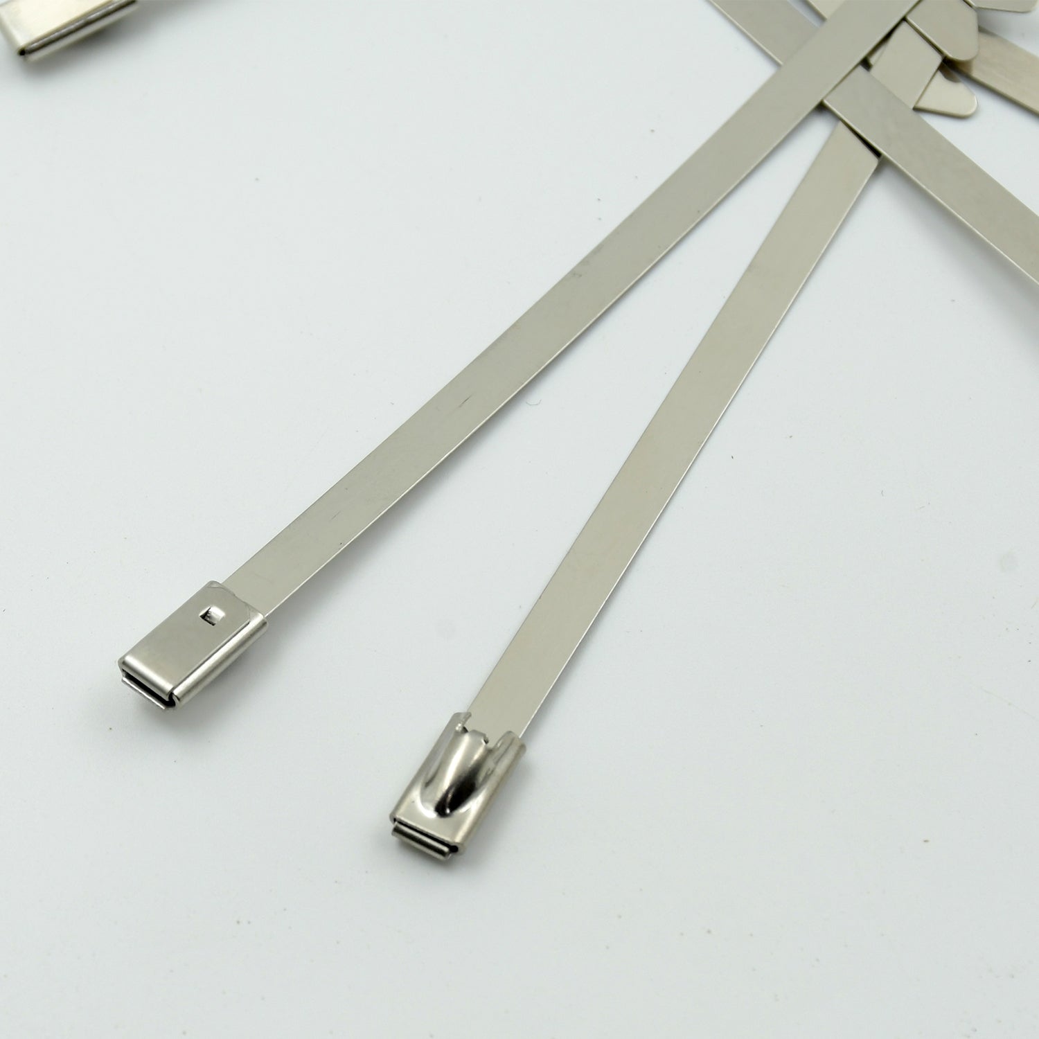 Durable stainless steel cable tie securing electrical wiring in an industrial setting.