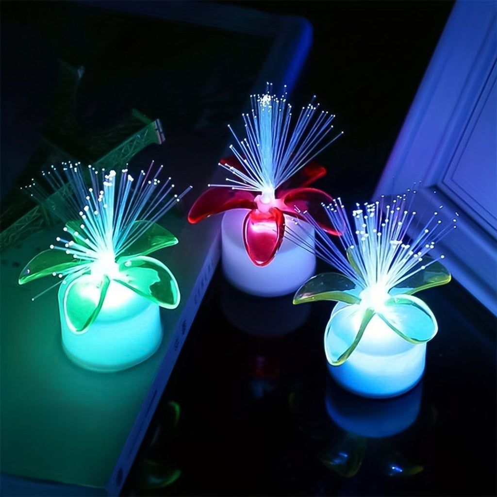 A group of fiber optic LED centerpieces illuminating a dark room.