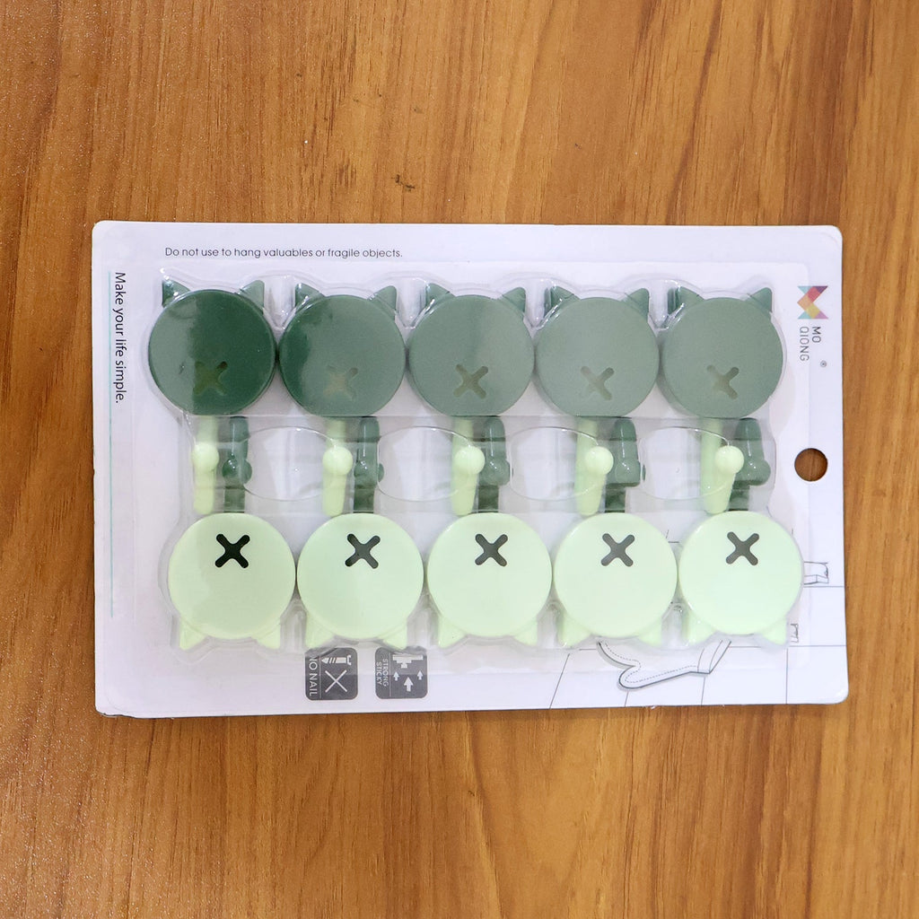 Self adhesive hooks used to hang measuring spoons in the kitchen