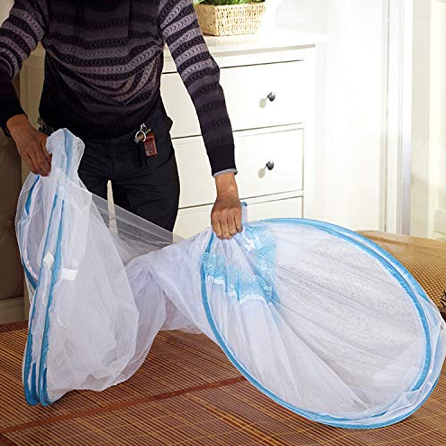 Self-supporting foldable polyester mosquito net tent setup over sleeping area