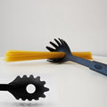 Black heat-resistant pasta server scooping spaghetti from a pot, showcasing its non-stick design.