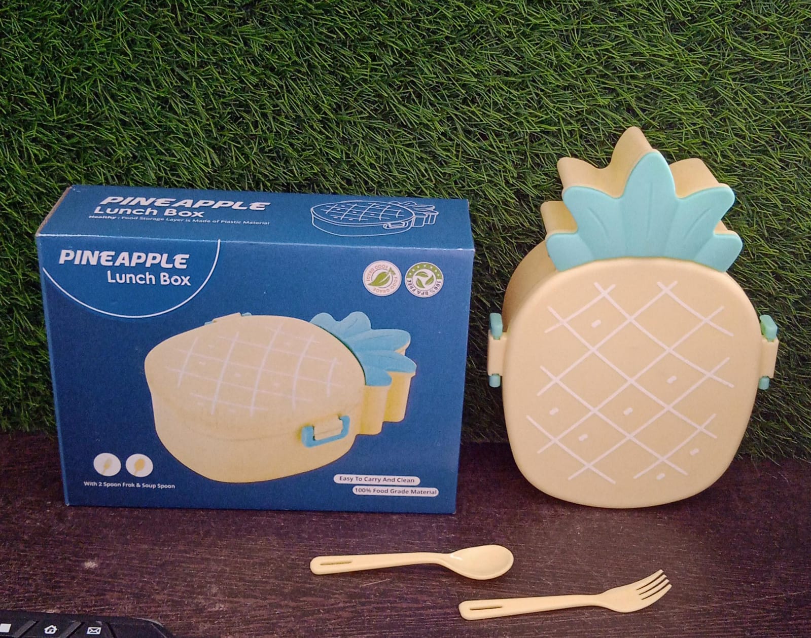 Colorful retail packaging box for the pineapple kids bento lunch box, showcasing its features.