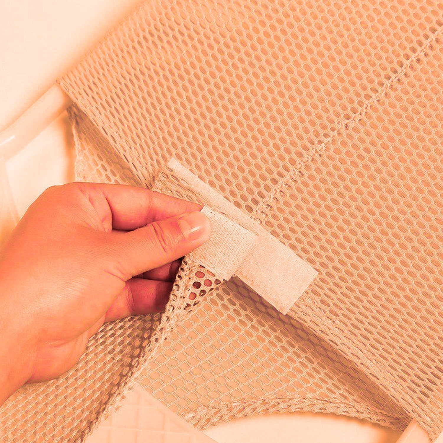 A comfortable white baby bath seat with a gentle recline, ideal for safe infant bathing.
