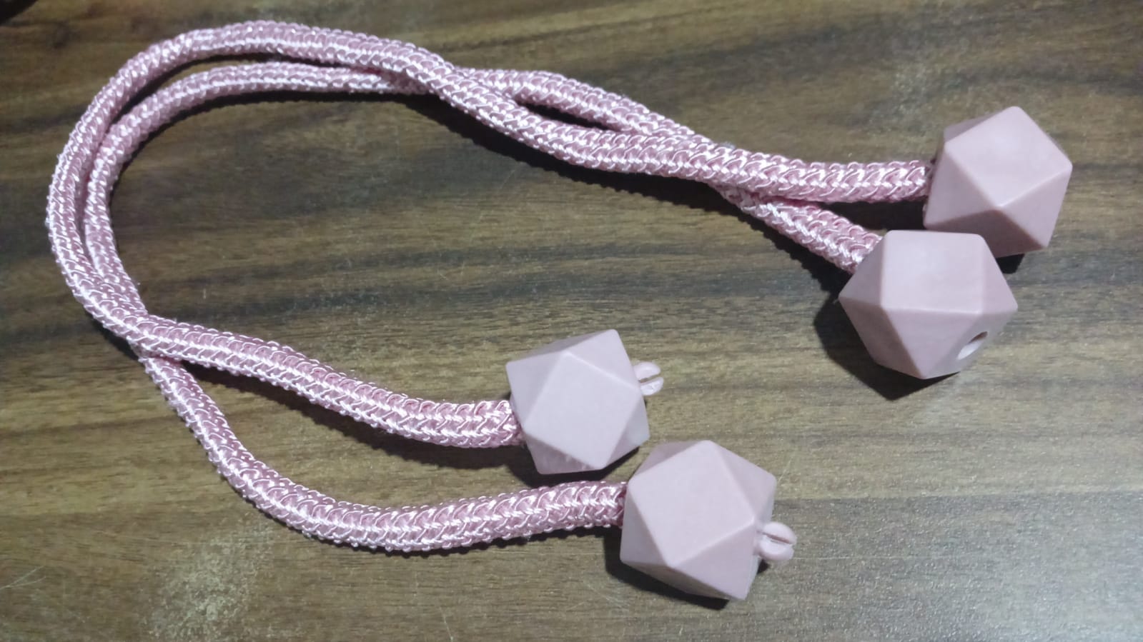 Detailed shot of the durable plastic and pearl elements of the curtain tieback.