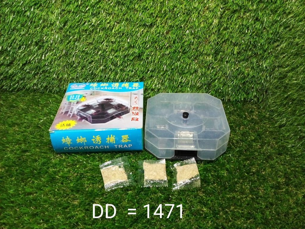 A blue box labeled "COCKROACH TRAP," a clear plastic trap, and three packets of bait are on a green artificial grass surface.