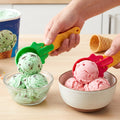 Two plastic ice cream scoops with colorful green and red handles, ready for serving.