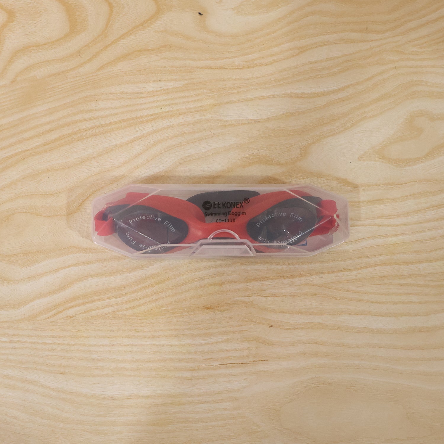 Swimmer using red anti-fog goggles in water environment