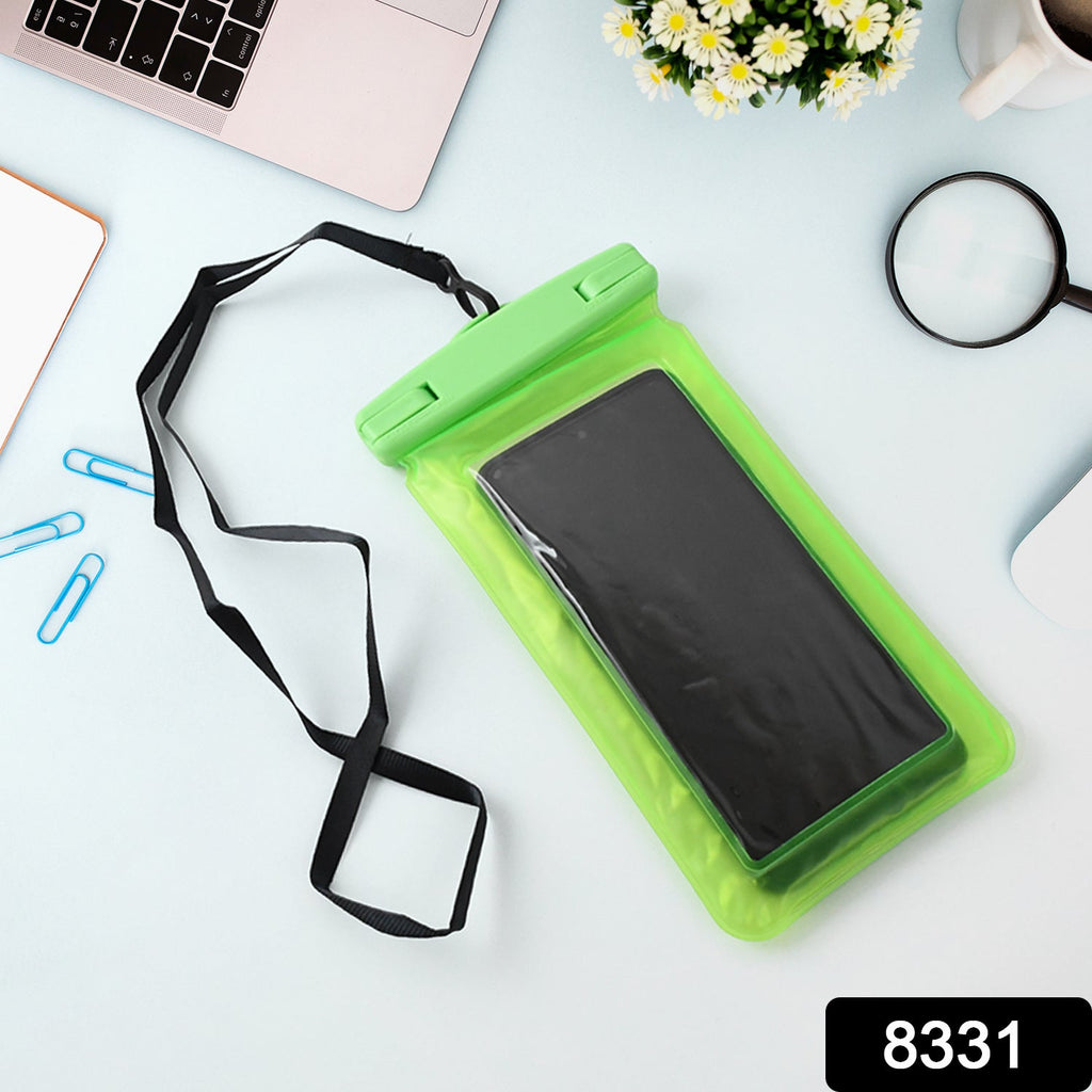 A green clear phone pouch with a black smartphone and lanyard rests on a light blue desk with a laptop, paper clips, and