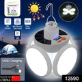 A white Quickslice solar camping light with four bright LED panels illuminates a dark campsite with a tent.