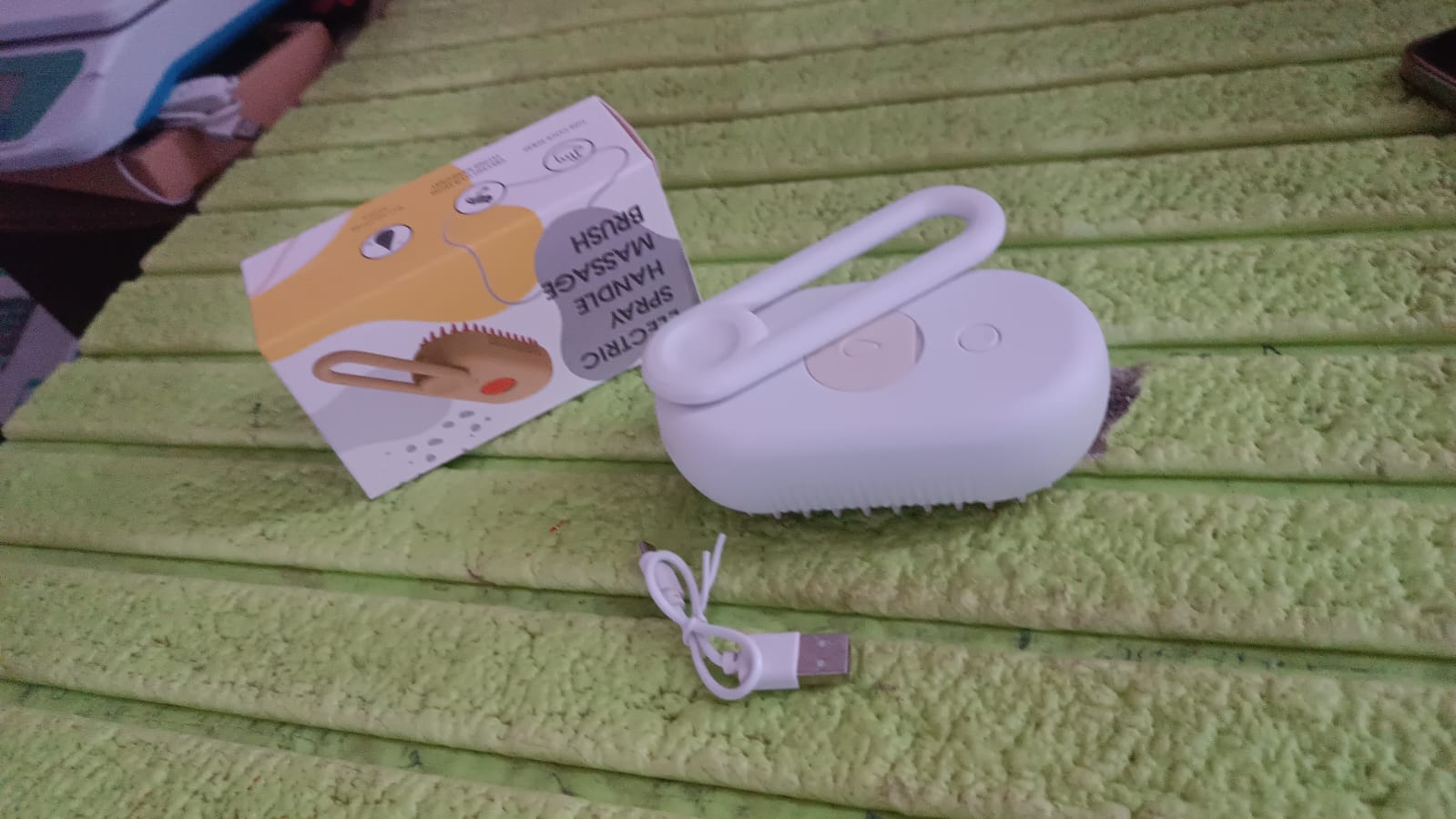 All components of the electric pet steam brush laid out for cleaning.